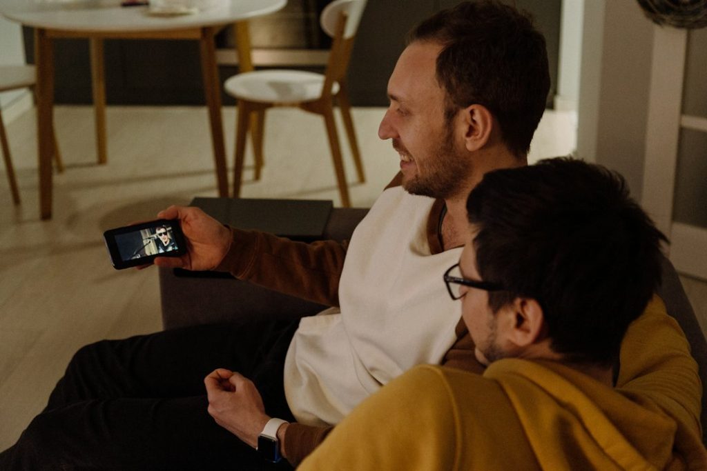 Dua orang menikmati konten melalui smartphone