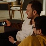 Dua orang menikmati konten melalui smartphone