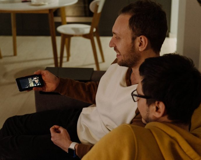 Dua orang menikmati konten melalui smartphone